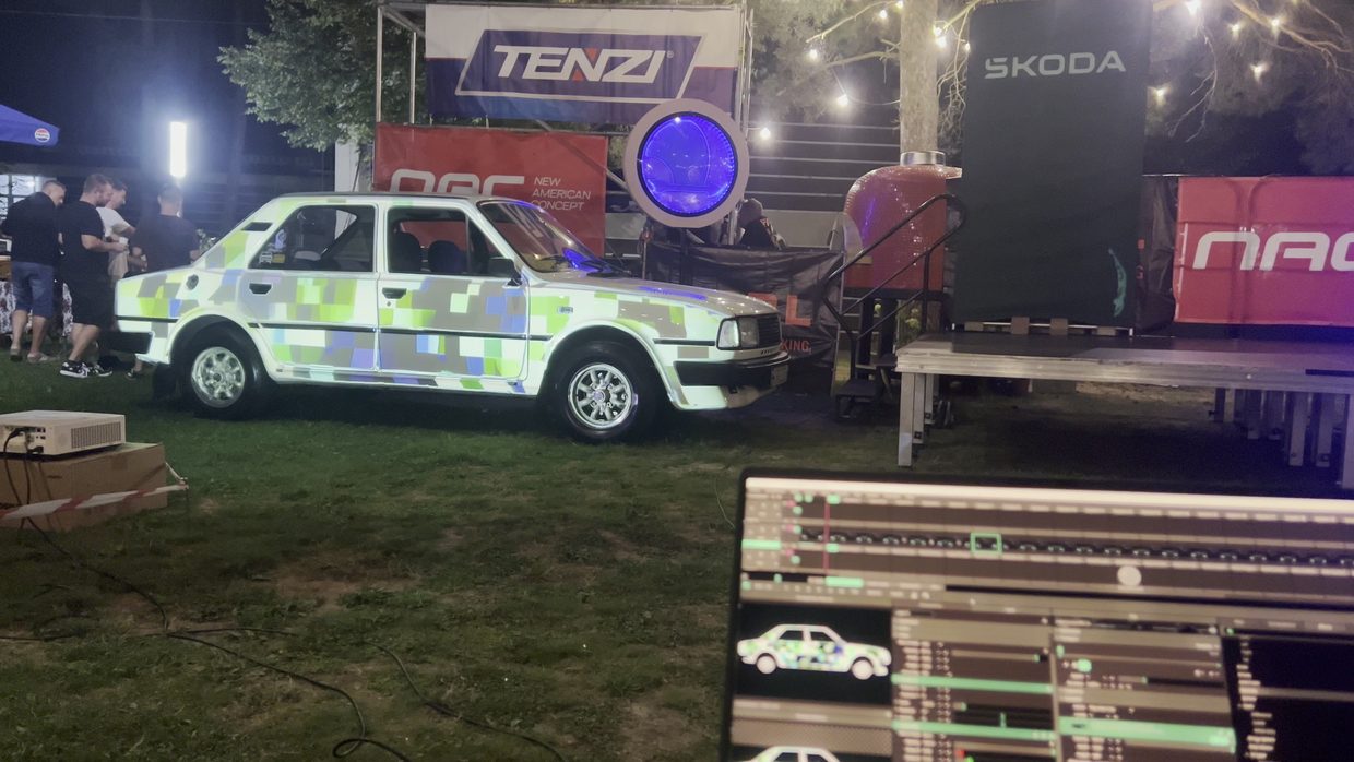 A projection on a car at an outdoor event.